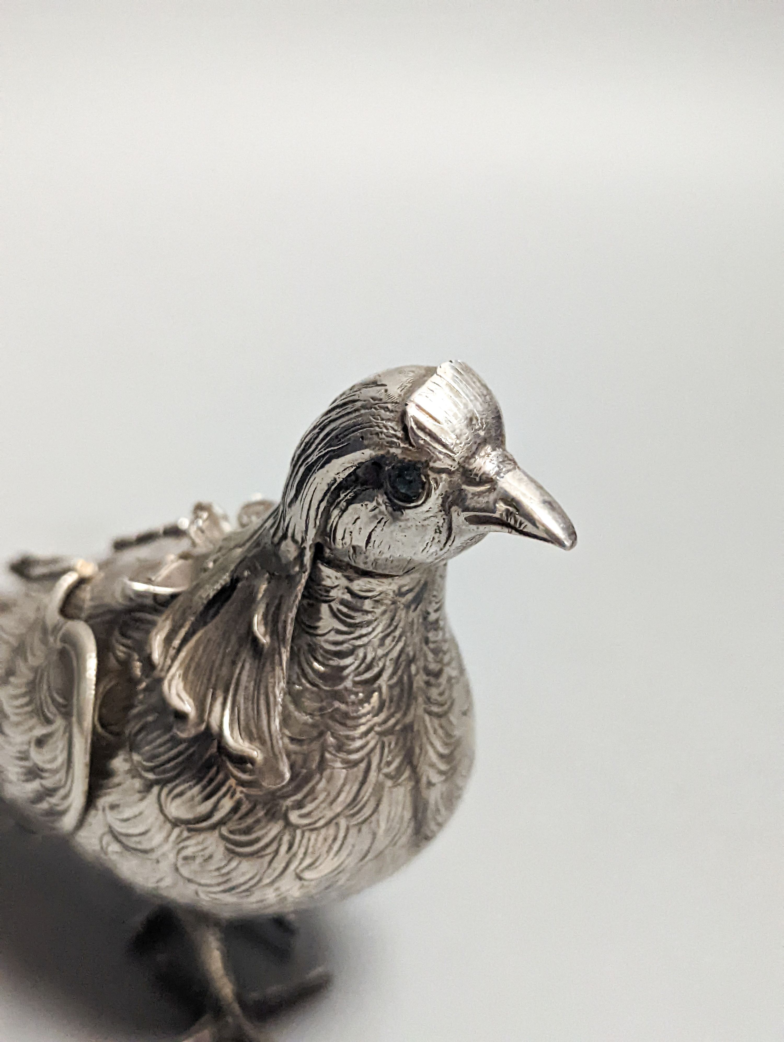 A late 19th century Hanau 800 white metal novelty condiment?, modelled as a game bird, with articulated wings and removable head, 22.4cm, gross 139 grams.
